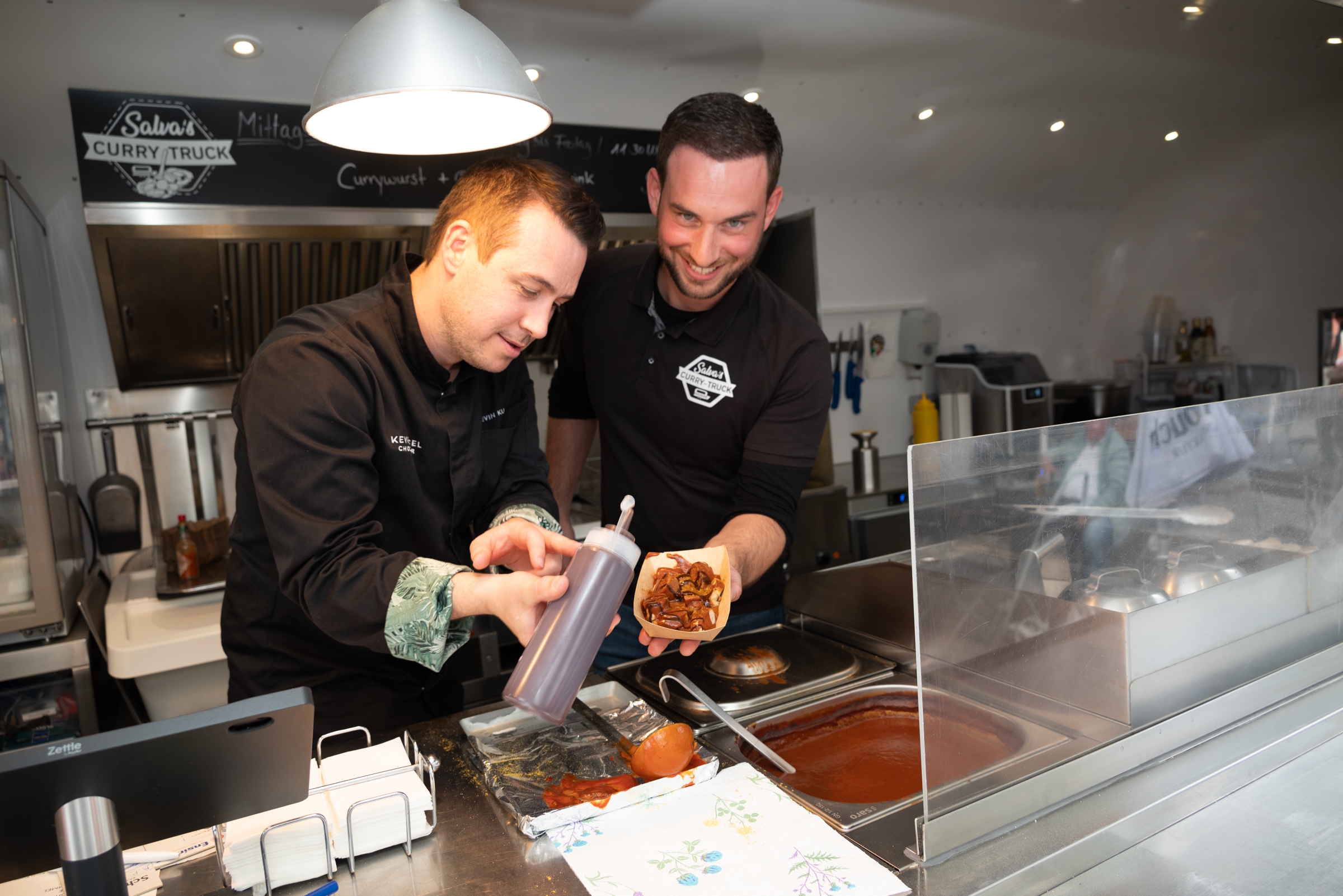 Kevin Kugel (links) und Salvore Romeo bei der Herstellung ihrer neuen Currywurst. Bild: Nüßle
