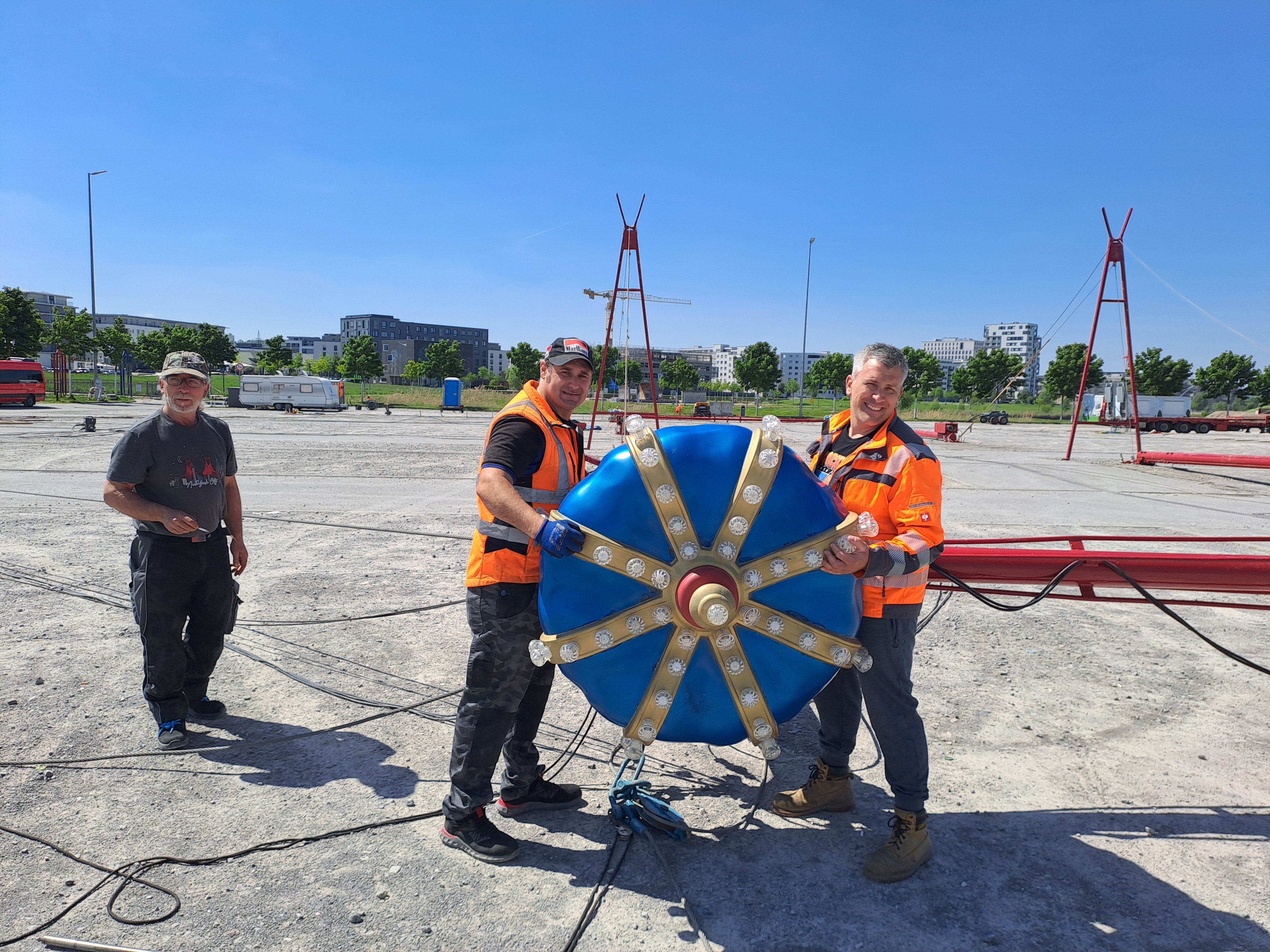 Die Mitarbeiter des Münchner Circus Krone Lorenzo Carnivali (links) und Robert Fossit (rechts) präsentieren die Krone, die ab Montagmorgen das 16 Meter hohe Zirkuszelt auf dem Festplatz Flugfeld zieren wird.