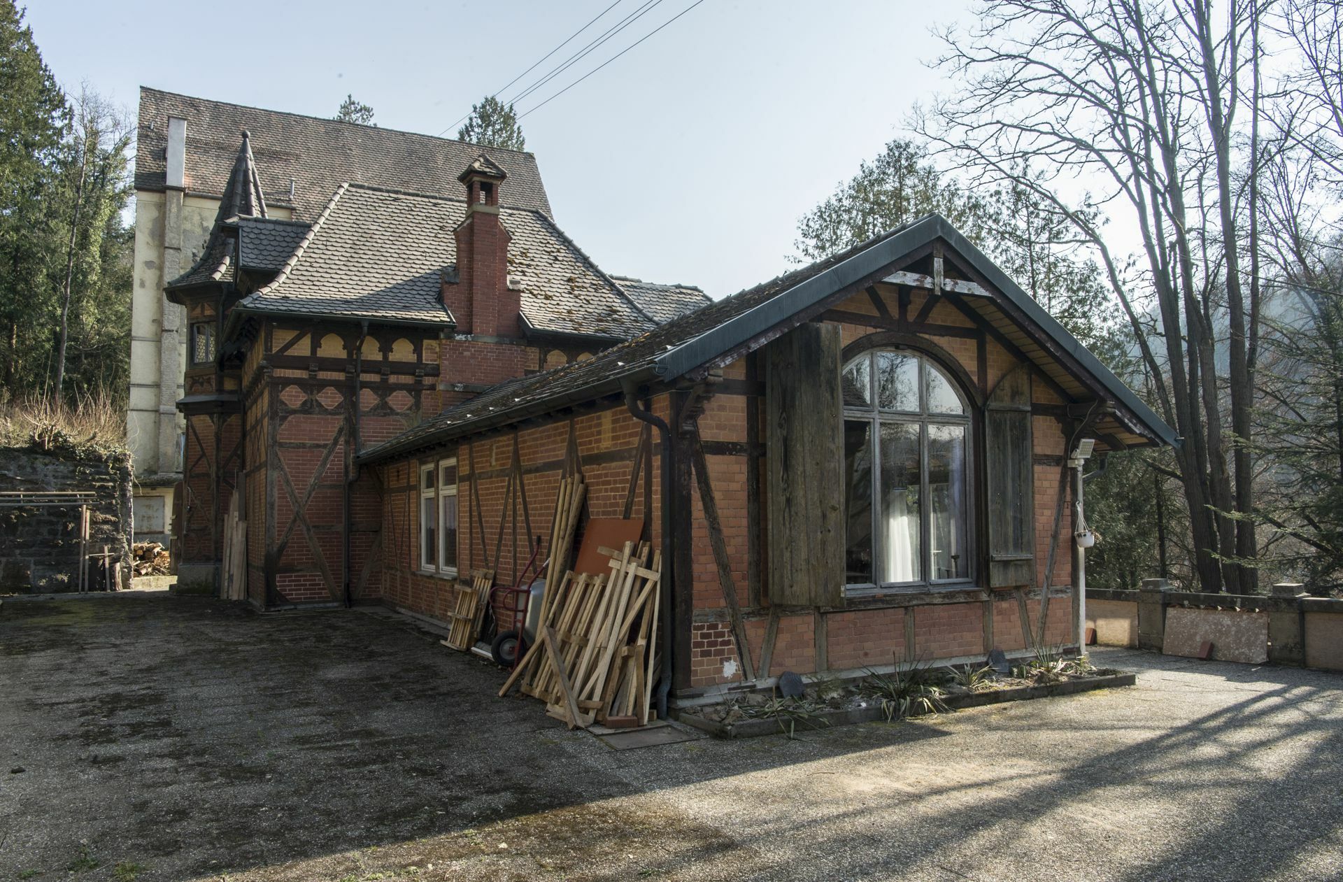 Im Hintergrund die expressionistische Anwesen. Daneben ließ Kilian von Steiner im 19. Jahrhundert einen Gartenpavillon errichten. Hier die Rückseite des Gartenpavillons. An dieser Seite befindet sich ein kleiner Salon. Zwischen Salon und Speisesaal war eine nach vorne, zum Wald hin geöffnete Ruheliegefläche – überdacht und zugleich offen, so konnten die Damen und Herren auch bei Regen im Liegestuhl liegen und die gute Luft atmen.