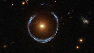 Im Zentrum dieses seltenen Einsteinrings liegt die extrem massereiche Galaxie LRG 3-757. In ihrem Zentrum haben Astronomen jetzt das massereichste je entdeckte Schwarze Loch nachgewiesen.