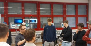 Schüler der Fachschule für Technik erklären den „Erasmus“-Teilnehmern, wie der KI-Roboter funktioniert.