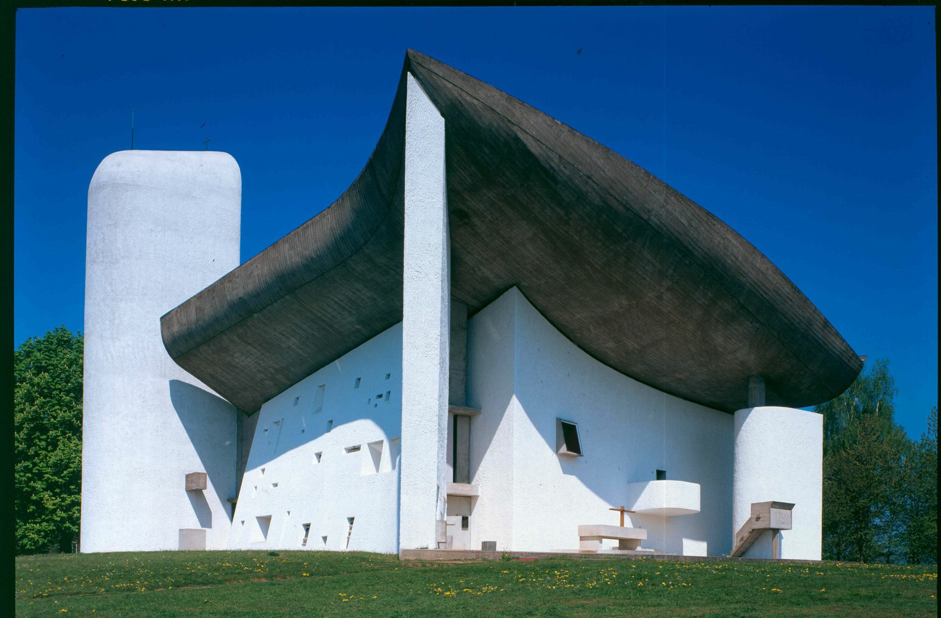 Die Kapelle Notre Dame du Haut von Ronchamp. Der 1950 bis 1955 nach Plänen von Le Corbusier Kirchenbau zählt zu den berühmtesten seiner Art in der Moderne. Seit  2016 ist der im Stil des „Brutalismus“ errichtete Sakralbau offiziell als Unesco-Weltkulturerbe gelistet.