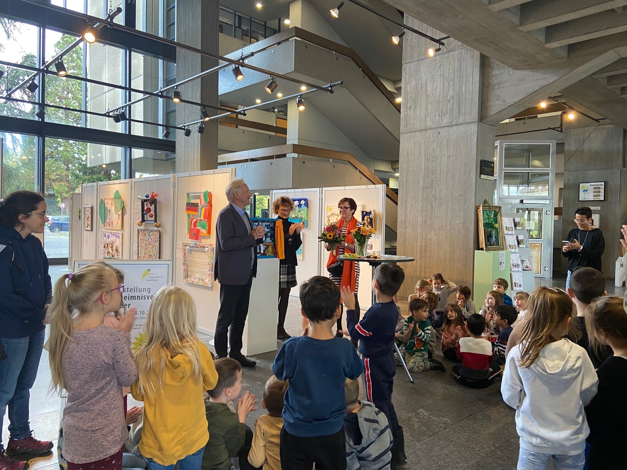 Joachim Schmidt von der Bürgerstiftung Sindelfingen neben der Gesamtleiterin der Sindelfinger Kitas Andrea Ragnit und Projektleiterin Sabine Weber (von links) bei der Vernissage im Rathaus.  Bild: Gluiber