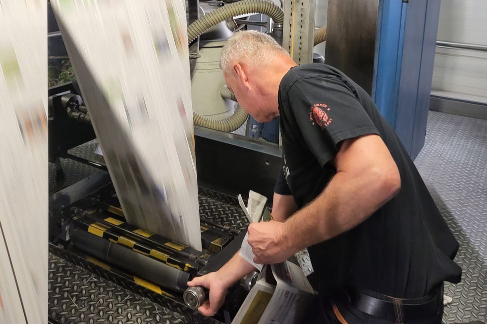 Vom endlosen Papierstreifen zur fertigen Zeitung: Joachim Reiser passt die Druckmaschine an.
