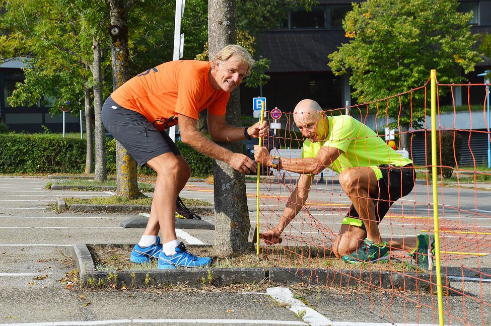 Mit dem Schäferzaun haben Axel Stahl und Bernd Ammer am Freitagmorgen noch vergleichsweise leichtes Spiel. Dieser soll in der Wechselzone auf dem Parkplatz für den nötigen Abstand sorgen. Heftiger wird es später, wenn ein knapper Kilometer Baugerüst zu Radständern werden.Bild: Wegner