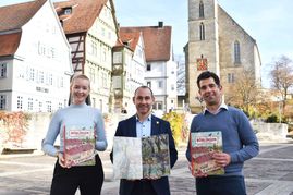 Citymanagerin Kira Morgan, Oberbürgermeister Dr. Stefan Belz und Stadtmarketingmanager Julian Spohn mit dem Böblinger Wimmelbuch. Bild: z