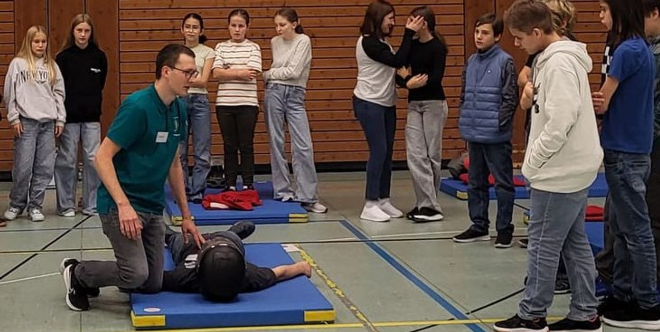 Dominik Urbanek zeigt den Schülern wie einem Unfallopfer der Helm abgenommen wird. Bild: Cardoso