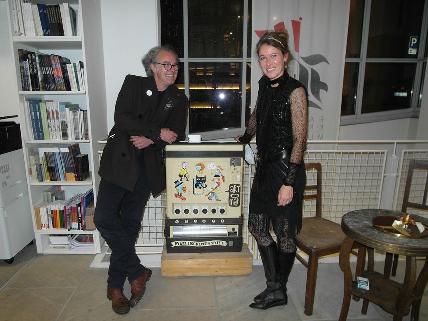 Marcus Gwiasda (links) und die Leiterin der Städtischen Galerie Böblingen Corinna Steimel feiern den Einstand des "Artomat", aus dem sich künftig an der Außenfassade der Zehntscheur kleine Kunst-Objekte ziehen lassen - zum Auftakt bestückte Marcus Gwiasda den Kunstautomaten mit aus Champagner-Muselets gefertigten "Korkenwesen". Bild: Staber