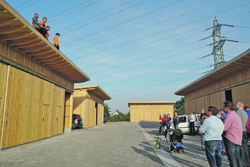 Gottfried Luginsland, zweiter von links auf dem Dach, hielt zur Eröffnungsfeier für das neue Schuppengebiet den Richtspruch der Zimmerleute auf einem der Schuppen.  Bild: Heiden