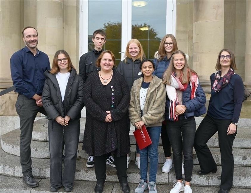 Ausgezeichnete Arbeit, hinten von links: Andreas Mohr (Geschichtslehrer und Tutor), Jarno Adam, Lara Butsch und Lilly Scholz. Vorne:  Jule Respondek, Kultusministerin Theresa Schopper, Neeshka Chavhan, Amelie Weber und Nadja Kimmerle (Geschichtslehrerin und Tutorin, von links).Bild: z