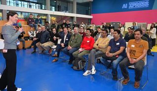 Dr. Kathrin Steinbrink (links mit Mikrofon), Head of AI xpress, freute sich über den großen Zuspruch am Durchstarten-Tag des Start-up- und Innovationszentrums. Neben Gründungsinteressenten in der ersten Reihe: Mentor Harald Grumser, Sparkassenvorstand Markus Linha und Geschäftsführer Hans-Ulrich Schmid.