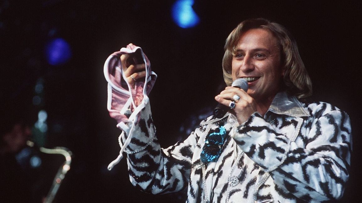 1998: Machen Sie eine typische Handbewegung... Kuhn mit BH und im Zebraanzug.
