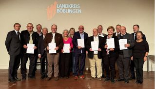 Landrat Roland Bernhard (vierter von rechts) mit den Laudatoren und den Geehrten.