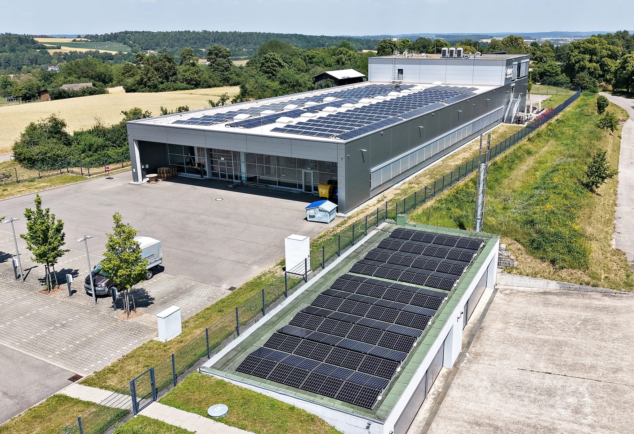 Aus der Luft gut zu sehen: Die Dachflächen von Produktion und Hangar werden von Elsner Elektronik komplett für Photovoltaik genutzt. Der neue Batteriespeicher am Hangar und der bestehende im Gebäude arbeiten für eine optimale Verteilung zusammen.
