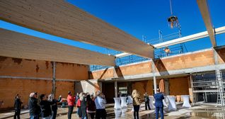 Bauleiter Friedrich Pineker bei seinem Richtspruch. Der Festkranz baumelt am Kranhacken.