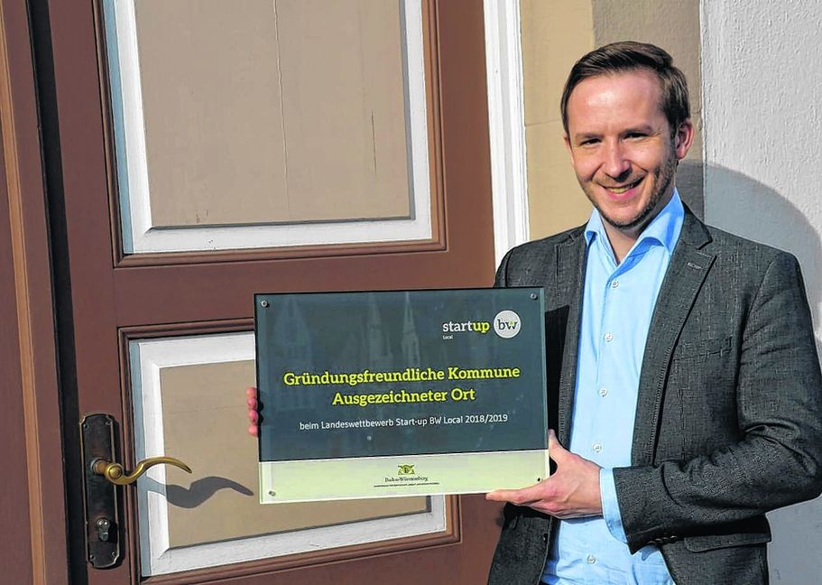 Bürgermeister Florian Glock: Die Auszeichnung als gründungsfreundliche Kommune ist für ihn die schönste Auszeichnung im ersten Amtsjahr und für die Gemeinde mit 100 000 Euro Fördermitteln verbunden. Er kann die Plakette zwar an die Eingangstür des Rathauses halten, darf sie aber nicht an die Außenwand des Gebäudes montieren, denn das Haus steht unter Denkmalschutz.  Bild: Reichert