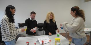 Lehrer Dzenan Sahović (Zweiter von links) und Efetka Alexiev (Zweite von rechts) lassen sich bei den Sindelfinger Wissenstagen von Jasmin Washash (links) und Giulia Anastasia Chiavello (rechts) deren frühpädagogische Mitmach-Station „Geruchs-Memory“ erklären.