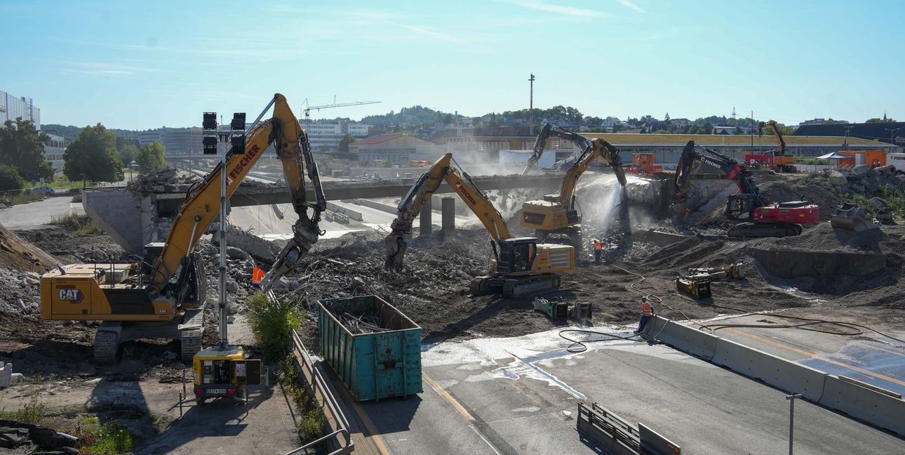 Bagger mit verschiedenen Aufgaben: Manche zerkleinern den Beton, manche trennen den Stahl vom Beton. Mit Wasser wurde gespritzt, um die Staubbildung zu unterbinden.
