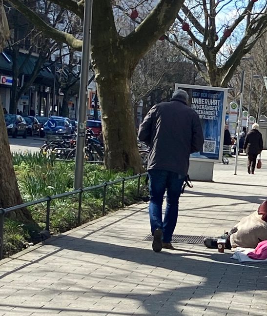 Eine Szene aus der Mercedes-Straße in Sindelfingen: Ein Bettler versucht über die Runden zu kommen, die meisten Passanten laufen vorbei. Bild: Christel