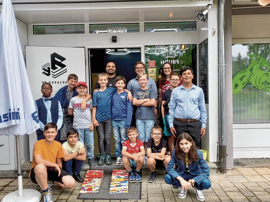 Die Lego-AG des Stiftsgymnasiums mit Schulsozialarbeiterin Michelle Fischer (hinten rechts), dem „Helfen statt Hamstern“-Vorsitzenden Maximilian Reinhardt (hinten Mitte) und Berkay Uslubas, Co-Inhaber von Mr. Barberko (hinten links).