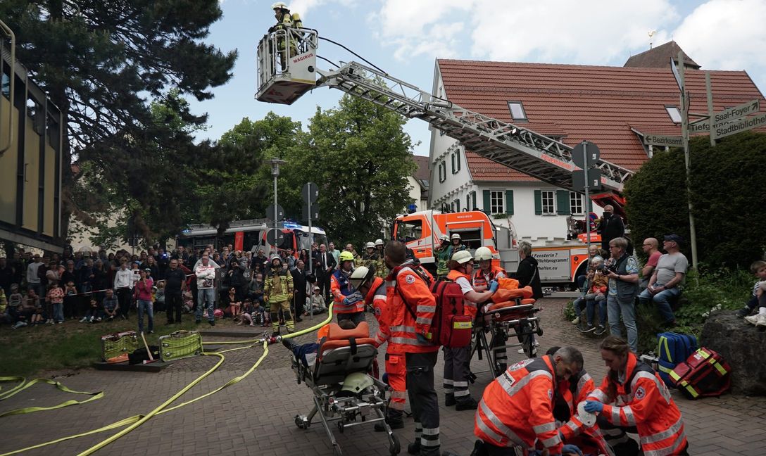 Mit einer Drehleiter werden Personen aus dem ersten Stock des Bürgerhauses gerettet.