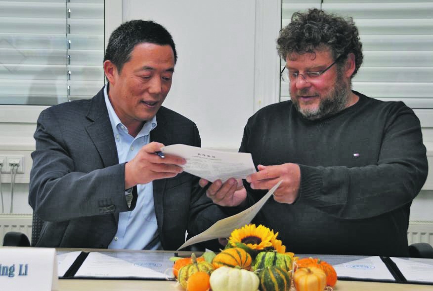 Professor Guangming Li (links) und Armin Kienle nach der Unterzeichnung des Kooperationsvertrags beim Austausch der Urkunden. Bild: Reichert