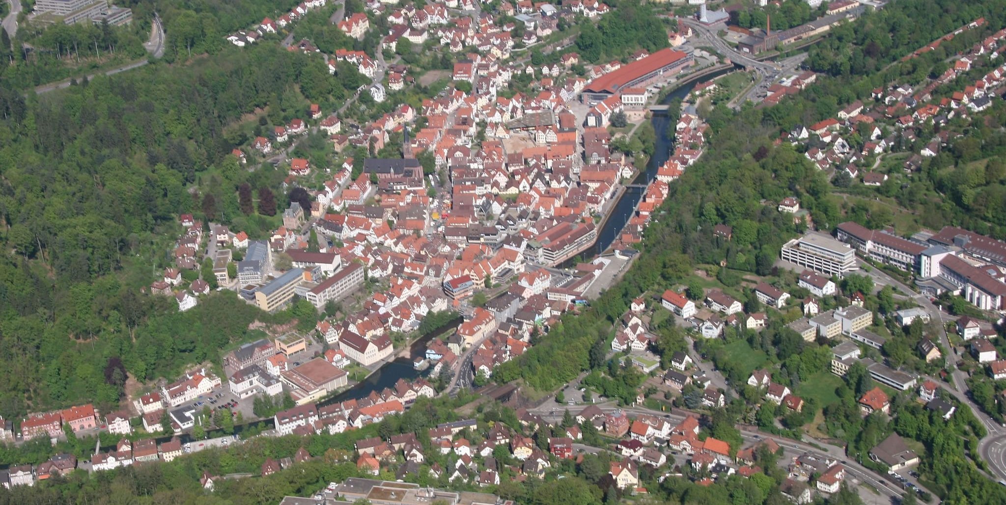 Die Hermann-Hesse-Stadt Calw aus der Vogelperspektive. Links ist das Schulzentrum Wimberg zu sehen, in der Mitte der Fluss Nagold und rechts das Krankenhaus.