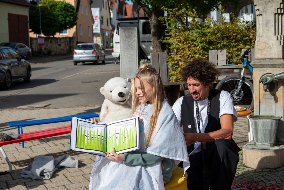 Emilia Menke liest nicht nur Frisör Danny Beuerbach vor, sieht zeigt auch den Zuschauern das ausgewählte Buch.