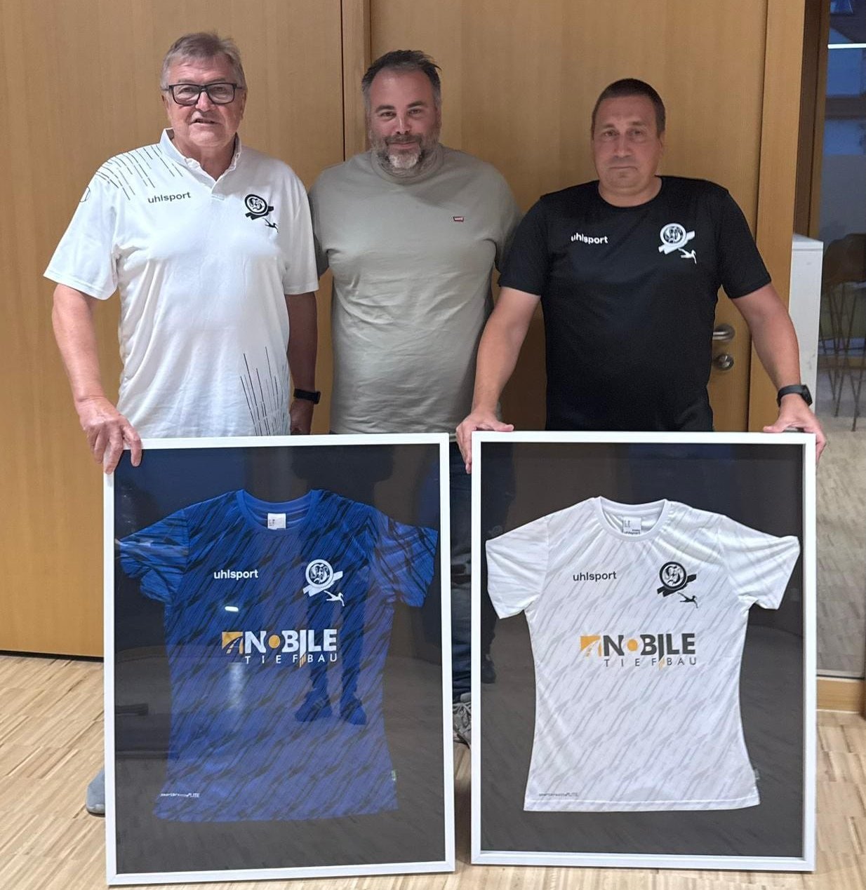 Josef Klaffschenkel (1. Vorsitzender, links) und Marc Pflieger (2. Vorsitzender, rechts) begrüßen Beisitzer Giuseppe Nobile mit von den Ladies-Spielerinnen unterschriebenen Trikots im Vorstandsteam.