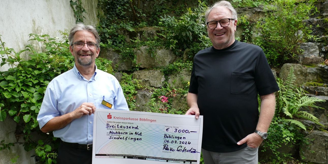 NiN-Vorsitzender Jürgen Haar (rechts), Ex-Chefredakteur der SZ/BZ, nimmt den Scheck aus den Händen von Rainer Scholz vom Rapir-Café entgegen.