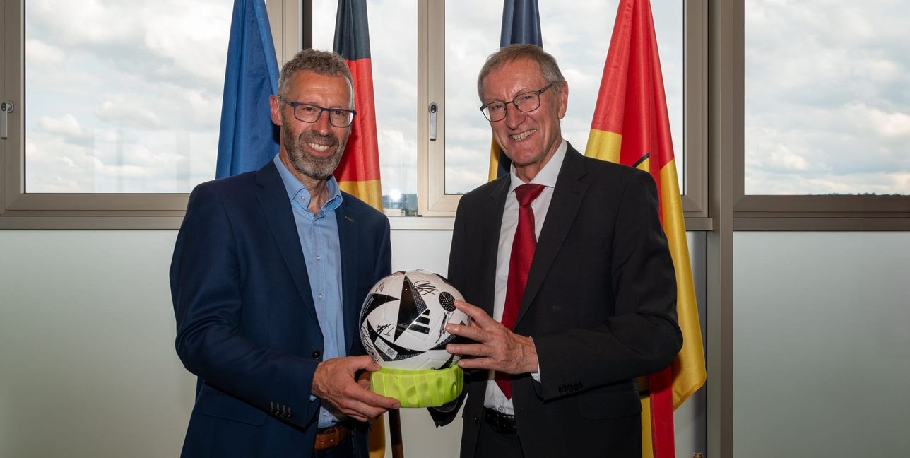 Der erste stellvertretende Vorsitzende des Kreistags, Thomas Sprißler, gratulierte dem alten und neuen Landrat Roland Bernhard im Namen des Kreistags zum Wahlsieg. Damit er weiter am Ball bleibt hat Landrat Bernhard einen Ball mit Unterschriften der VfB-Spieler und ein Torwarttrikot der deutschen Nationalmannschaft erhalten.