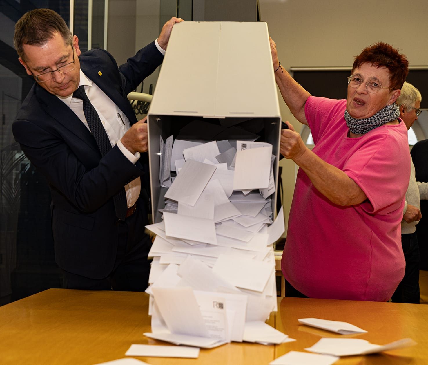 Der erste Beigeordnete Peter Müller und eine Wahlhelferin lassen die Stimmzettel aus der Wahlurne purzeln.
