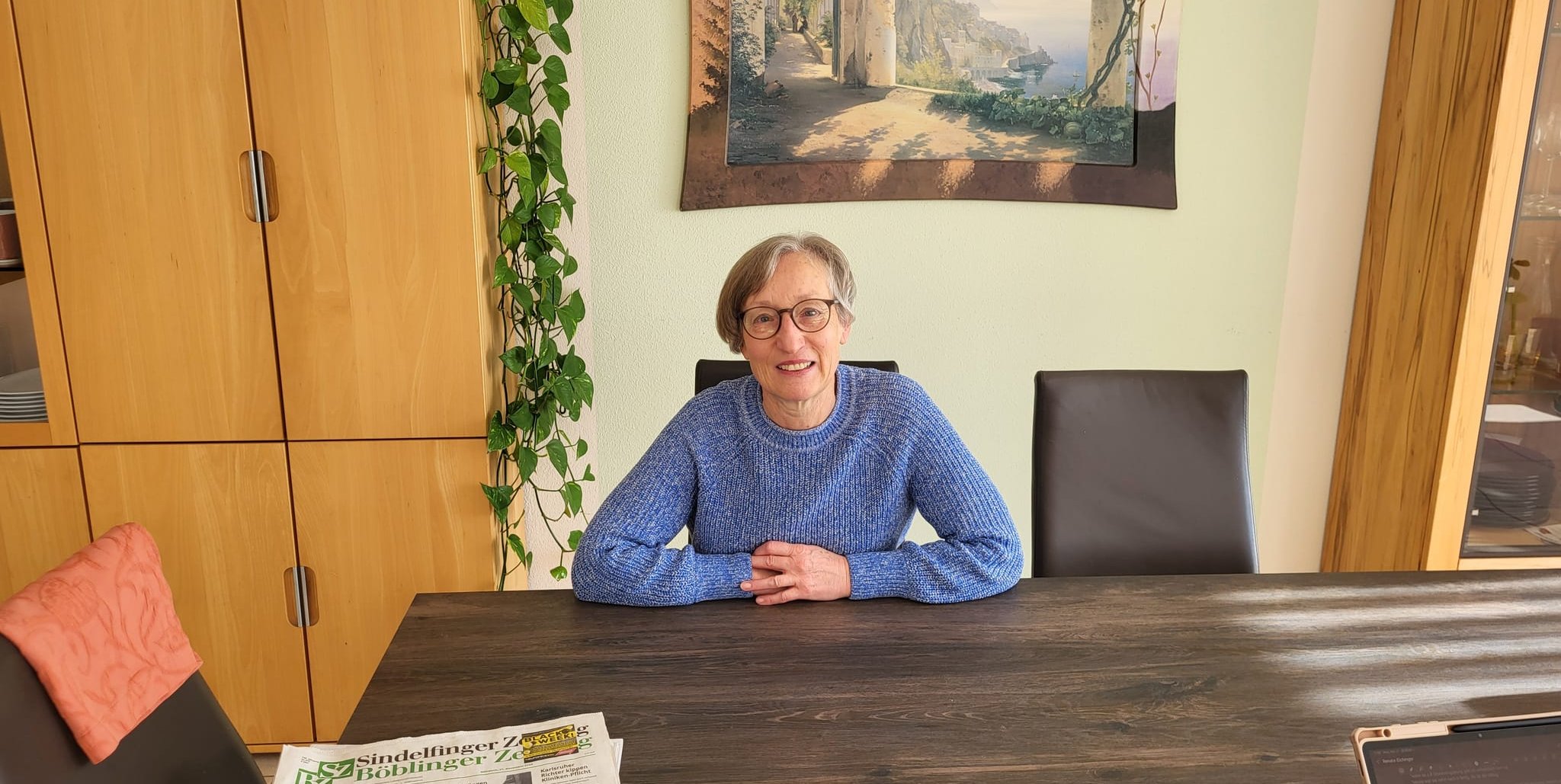 Renate Eichinger sitzt in ihrem mit Liebe eingerichteten Wohnzimmer, auf dem Tisch liegt eine SZ/BZ-Ausgabe.
