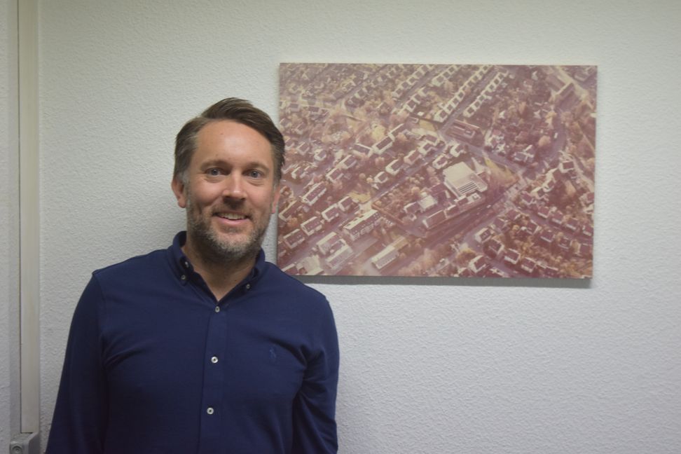 Johannes Schlanderer, Geschäftsführer von Gastrogetränke Schlanderer, vor einem Bild des Firmengeländes aus dem Jahr 1984.