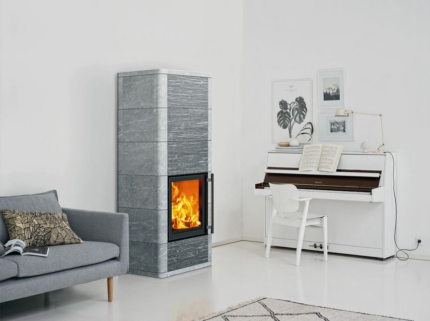 Elegant fügt sich ein Specksteinofen mit seinen abgerundeten Kanten in das puristische Ambiente ein. (Foto: epr/Tulikivi)
