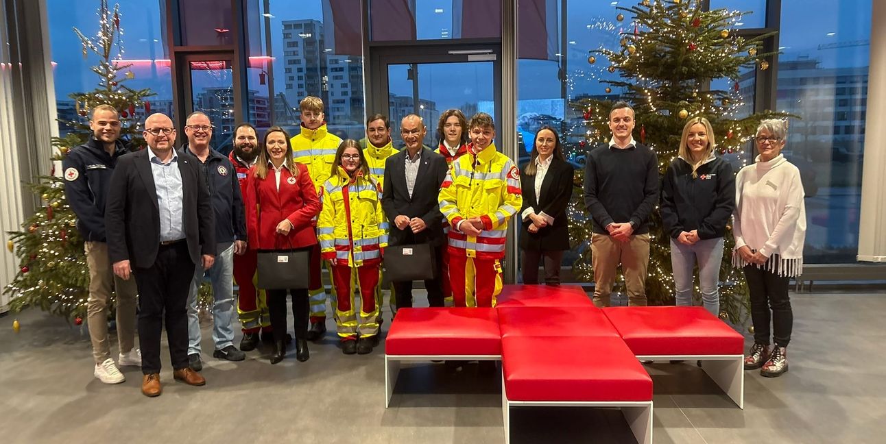Die DRK-Heiligabend-Tour: Präsident, Vizepräsidentin und die Führungskräfte vor dem Verteilen der Geschenke.  Landtagsabgeordneter Hans Dieter Scheerer – Präsident (Neunter von links), Bundestagsabgeordnete Jasmina Hostert – Vizepräsidentin (Fünfte von links), Wolfgang Hesl – Kreisgeschäftsführer (Zweiter von links), Sonja Hein – stellvertretende Kreisgeschäftsführerin (Vierte von rechts), Jens Kegreiß – Rettungsdienstleiter Nord (Dritter von rechts) und Vanessa Heni – Regionalleitung Süd (Altenpflegeheime) (Zweite von rechts). 	Bilder: DRK