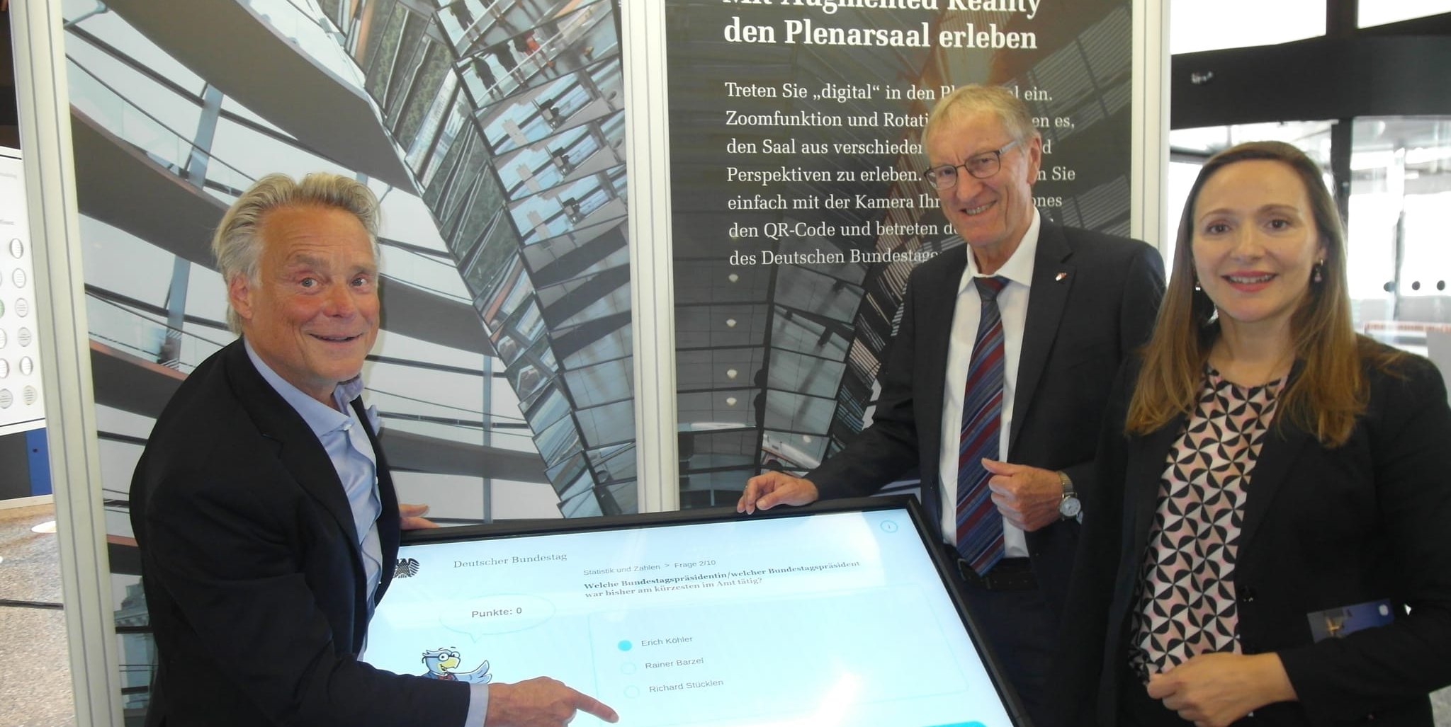 Michael Kresin, der als freier Mitarbeiter die Wanderausstellung des Deutschen Bundestags betreut, Landrat Roland Bernhard und die SPD-Bundestagsabgeordnete Jasmina Hostert (von links) zeigen, wie die Exponate um interaktive Elemente erweitert wurden.