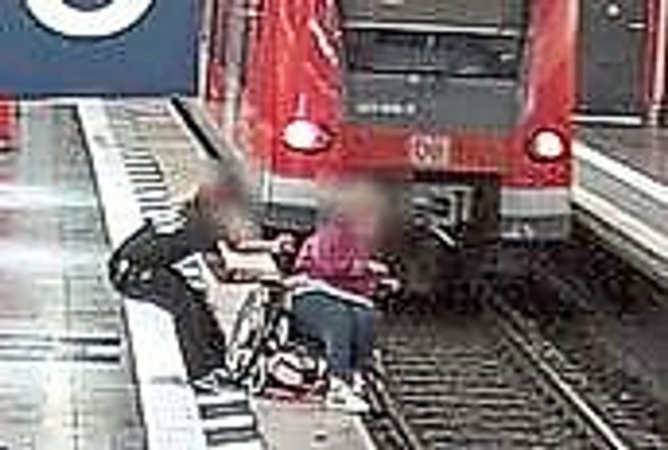 Das Bild einer Überwachungskamera zeigt, wie Jürgen Hermann die Rollstuhlfahrerin im Münchner Hauptbahnhof vor dem Absturz bewahrt.
 Foto: Bundespolizeidirektion M..