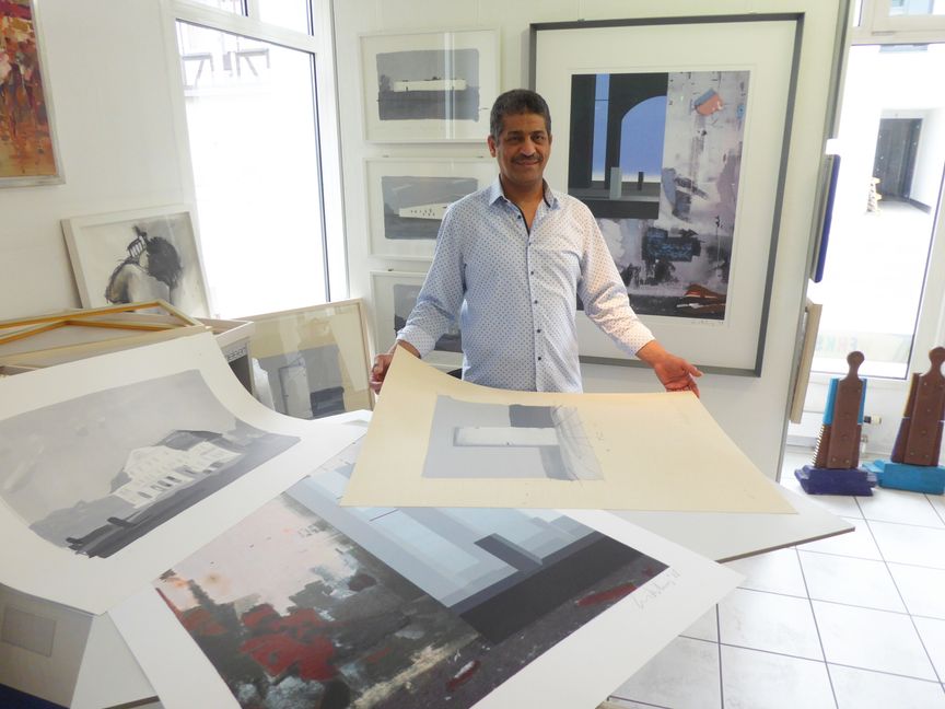 Hesham Hassan in seinem Kunst- und Posterhaus an der Oberen Vorstadt mit knapp einem Dutzend Drucken von Ben Willikens, der seine große Retrospektive im Schauwerk Sindelfingen eröffnet hat. Bild: P. Bausch