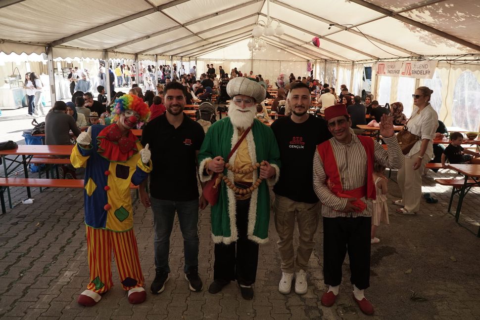 Jugendleiter Ahmed Gülec (Zweiter von links) und Kulturfest-Organisator Fatih Sevik (Zweiter von rechts) zwischen kostümierten Festfiguren.