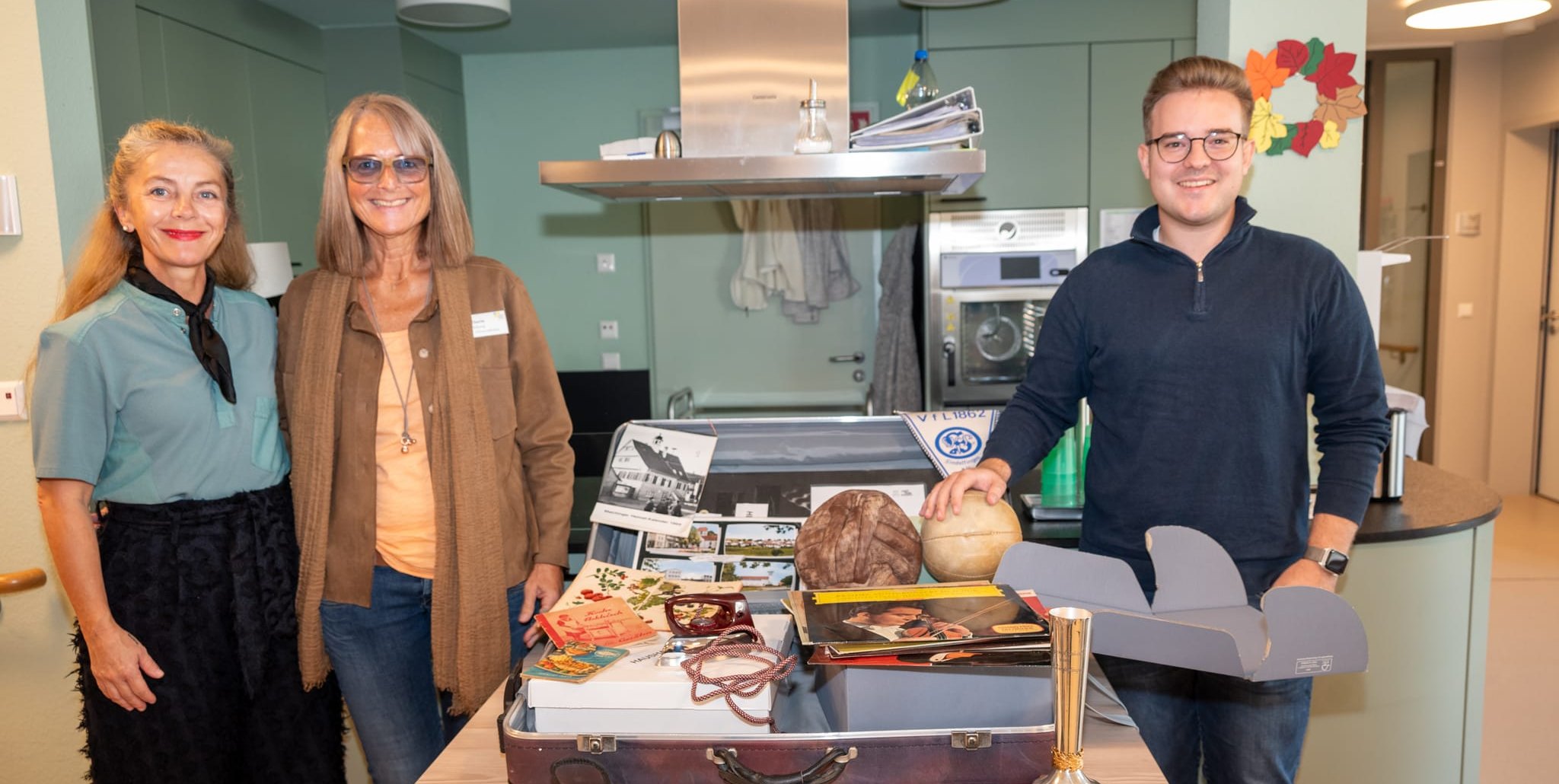 Monika Pildner-Modjesch und Uta Eberle erhalten von Max Reinhardt den ersten Erinnerungskoffer. Bild: Nüßle