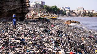 Ein Sandstrand, dessen Sand gar nicht mehr zu sehen ist: Massen an Klamotten vermüllen diesen Küstenabschnitt von Accra.