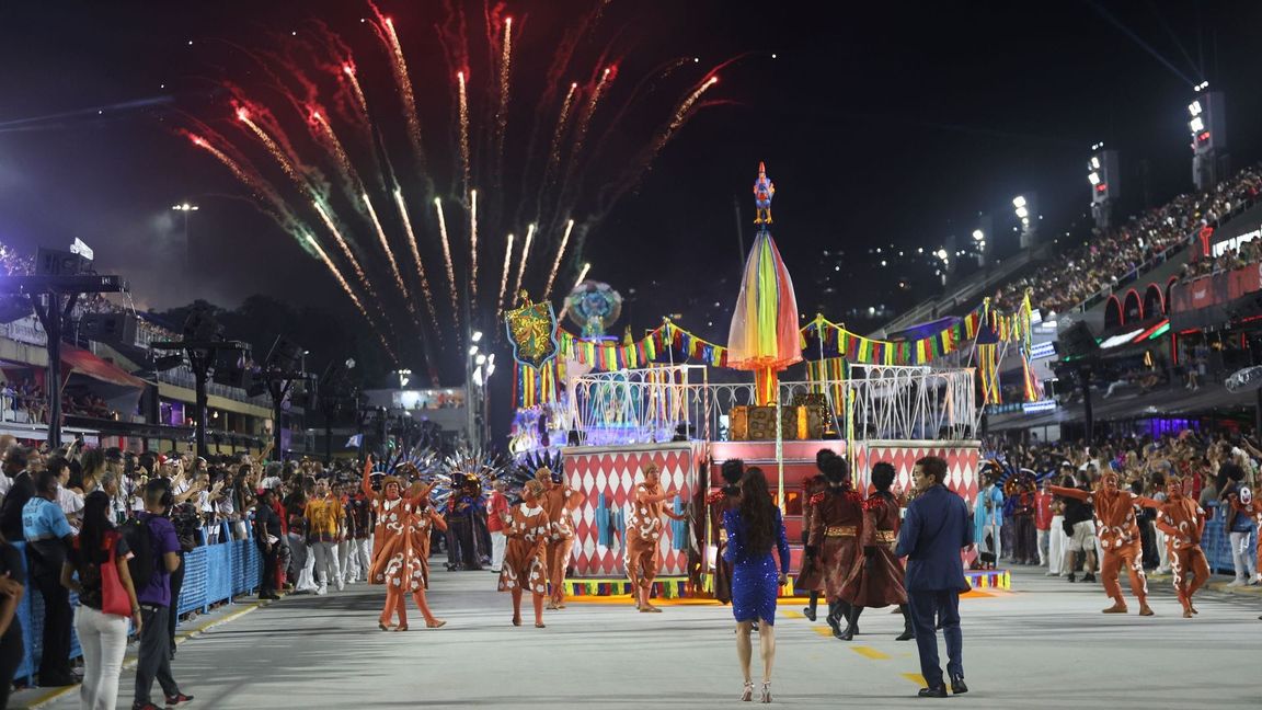 Mehrere Sambaschulen ziehen mit bunten Wagen durch die Straße.