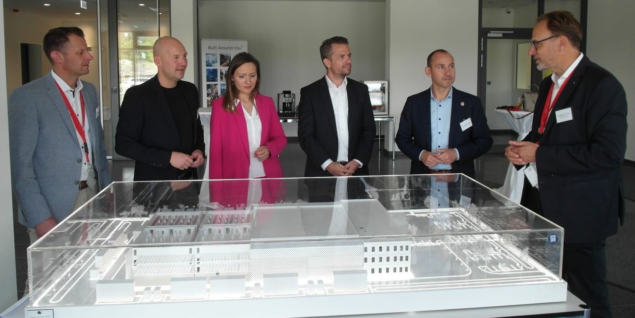 Von links: Sebastian Schmid (Geschäftsführer ADK Modulraum), CDU-Bundestagsabgeordneter Marc Biadacz, SPD-Bundestagsabgeordnete Jasmina Hostert, Georg Raiser (Managing Director für die DACH-Region bei AtlasEdge) und Oberbürgermeister Dr. Stefan Belz hören Holger Zultner (Managing Director Leadership Datacenter) zu.
