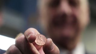 US-Schatzmeister Brandon Beach hält einen der letzten in der US-Münzanstalt in Philadelphia gepressten Pennys in die Kamera.