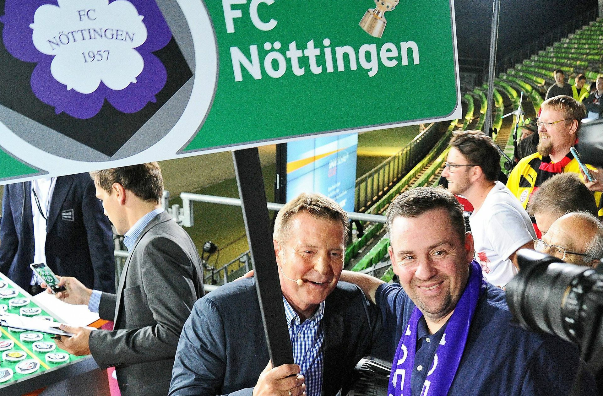 Dirk Steidl (re., neben Ex-Nationalspieler Karlheinz Förster), der Vorsitzende des FC Nöttingen,  sagt ganz lapidar: „Wir spielen Fußball und wollen gewinnen.“ Als einziger der   am Herzschlagfinale um den Direktaufstieg beteiligten Clubs  kann der FCN befreit aufspielen. Der  Tabellen-Siebten kann maximal noch einen Platz gutmachen. „Wir werden die Saison nicht austrudeln lassen und werden alles probieren“, verspricht Steidl, er sagt aber auch: „Die Erfahrung lehrt, dass wer vor dem letzten Spieltag oben steht, große Chancen hat, auch oben zu bleiben. Zumal wir zuletzt in keiner guten Verfassung waren und Freiberg über eine außergewöhnliche Offensivpower verfügt.“ Dass Kickers-Spieler Niklas Kolbe (früher FC Nöttingen) und viele Fans der Blauen bereits über 30  Kisten Bier zur Motivation für den FCN ausgelobt haben,  nimmt Steidl zur Kenntnis, glaubt aber nicht, dass es große Auswirkungen haben wird: „Beim Anpfiff ist das alles Makulatur.“