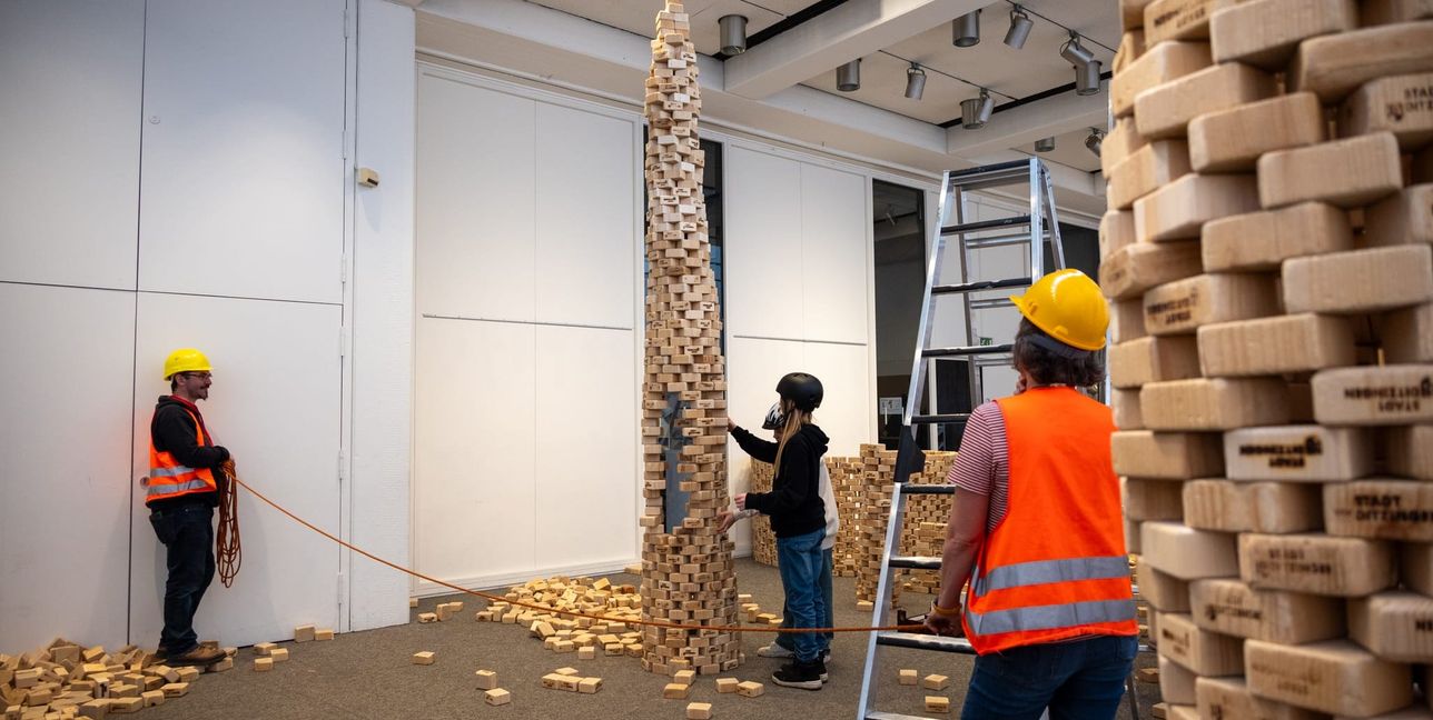 Nach dem Bauen geht es ans Einstürzenlassen, während Chris Schäfer (links) und Britta Hoß (rechts) die Baustelle absperren.