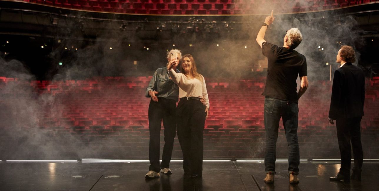 Wie Musicalstars: Gäste einer Backstageführung stehen auf der Bühne.