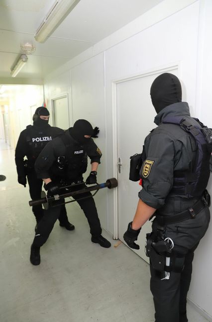 Ein Trupp der BFE öffnet in einem Asylbewerberheim in Korb am Neckar mit einer Ramme die Tür zum Zimmer eines mutmaßlichen Kriegsverbrechers. Foto: Feyder