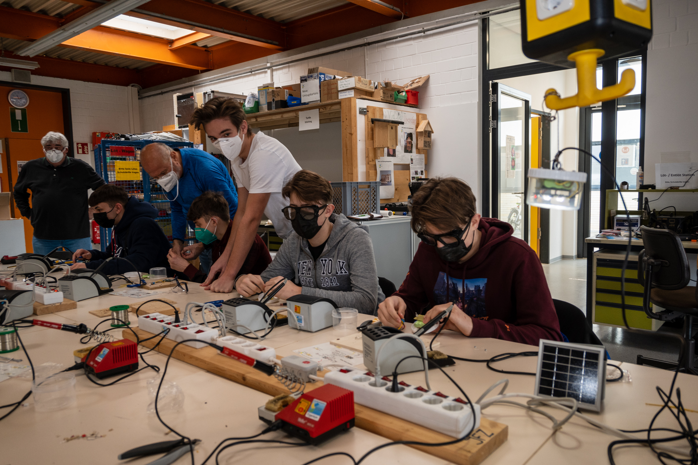 Krystian und Damian Florek, Amar Ramadani und Leon Jozic kommen dank der Tipps von Felix Schuber, Bruno Köngeter und Heinz Ulmer vom Jugendforschungszentrum gut vorn. Vorne rechts hängt ein fertiges Modell des Lichtspenders. Bild: Nüßle